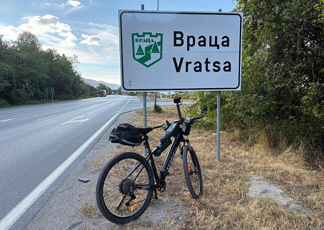 Електрически велосипед пред табелата на град Враца